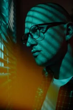 Man with Eyeglasses Looking through Window Blinds at Night Stock Photos