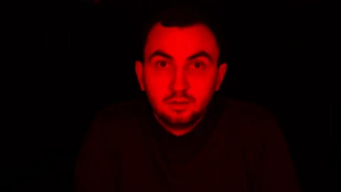 Man Face in Dark, with Red Glowing Light, Facial Expressions. Portrait of Devil Stock Footage 122126698