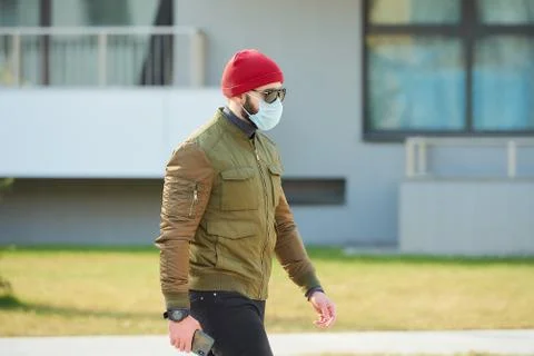 A man in a face mask to avoid the spread coronavirus holding a smartphone Stock Photos