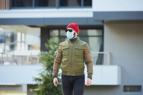 A man in a face mask to avoid the spread coronavirus holding a smartphone Stock Photos