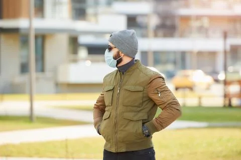 A man in a face mask to avoid the spread coronavirus waiting in the cozy stre Stock Photos
