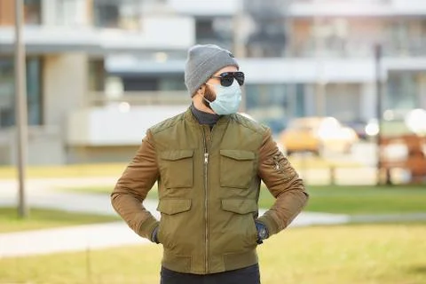 A man in a face mask to avoid the spread coronavirus waiting in the cozy stre Stock Photos