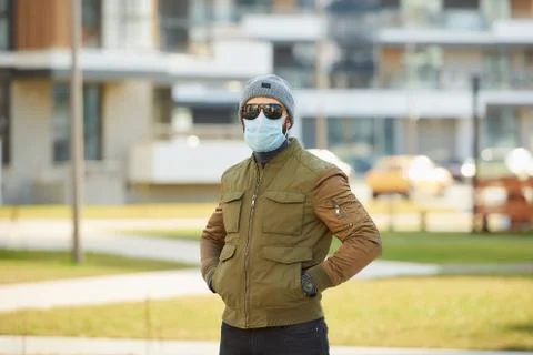 A man in a face mask to avoid the spread coronavirus waiting in the cozy stre Stock Photos