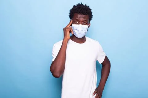 Man with face mask doing thinking gesture in studio 스톡 사진