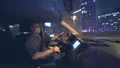 The man with a face mask driving in the car on the night city road 4k or 4k+ Resolution