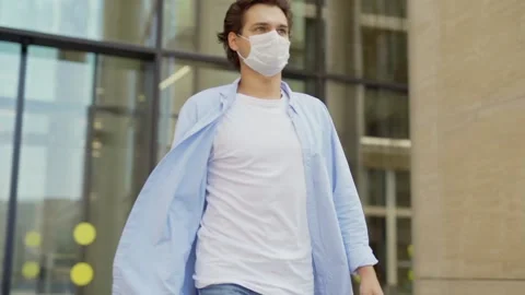 Man in face mask leaving office building Vídeos de archivo 134574840