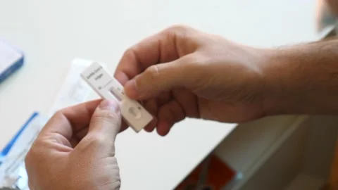 Man in face mask with self testing negative covid test. Covid-19 self-test Video stock 185591181