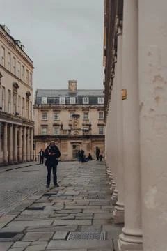 Man in face mask using phone standing on Bath street in Bath, UK. Stock-Fotos