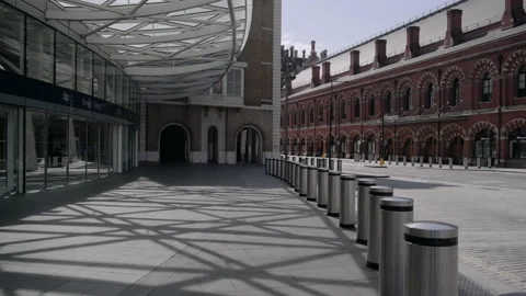 Man with face mask walking outside King's Cross underground station in London Stock Footage 130316635