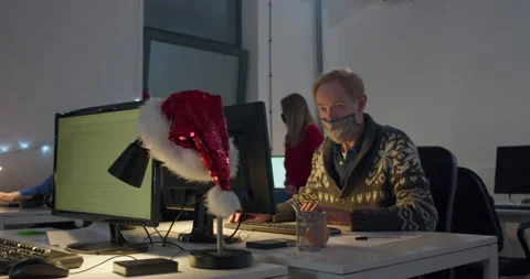 Man in face mask working on computer at desk at night Stock Footage 144271121