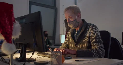 Man in face mask working on computer at desk at night Stock-Footage 144271249