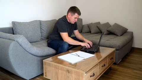 Man with face mask working with laptop smartphone call work from stay home Stock Footage 126999752