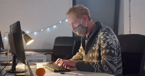 Man in face mask working in office at night 動画素材 144271759