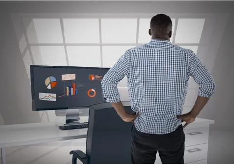 Man facing away looking out office window while data is on computer screen Stock Photos
