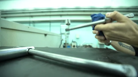 A man in a factory cleans a tool and puts it next to another Stock Footage 122244773