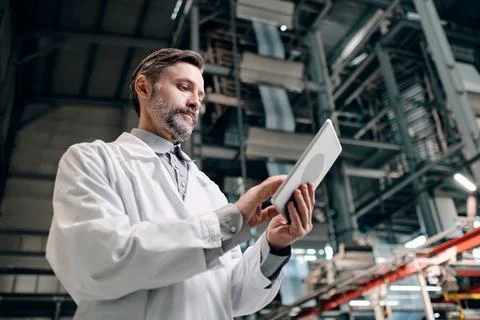 Man at factory with tablet Stock Photos