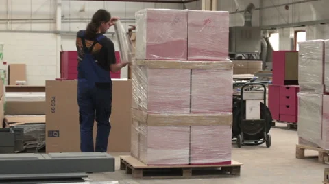 Man in Factory Wrapping Boxes on Pallet Stock Footage 55837301
