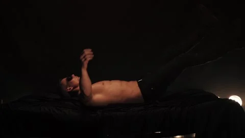 Man falling onto bed on black background Video stock 88744789