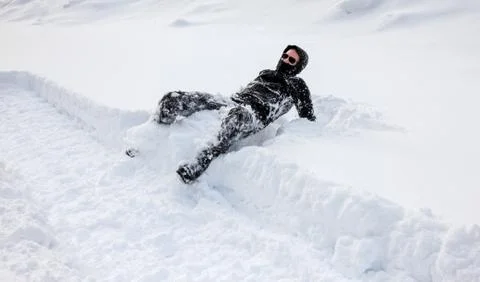 Man is falling into deep snow. Concept of winterly slippery conditions. Stock Photos