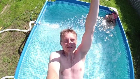 Man falls back into the swimming pool selfie Stock Footage 149416317