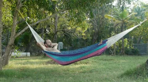 Man Falls out of Hammock Hard and Then Leaves in Frustration Stock Footage 10685095