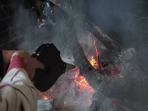 A man fan the fire of the fireplace Stock Footage 102230541