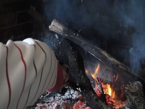 A man fan the fire of the fireplace Stock Footage 102230557