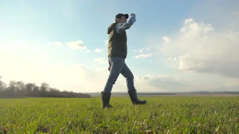Man farmer red a neck in cap is walking on a green field. lifestyle spring Stock Footage 136459951