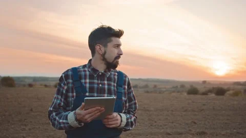 Man farmer use tablet computer stand look around on field at sunlight. Digital Stock Footage 169489076