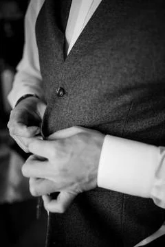 The man fasten a button on his jacket. The groom fasten a button on his jacke Stock Photos