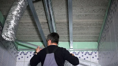 Man fasten ceiling profiles in new flat room Stock Footage 107252426