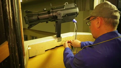 A man fastened to the wall a fastening ring for a safety wire of a theater Stock Footage 104254020