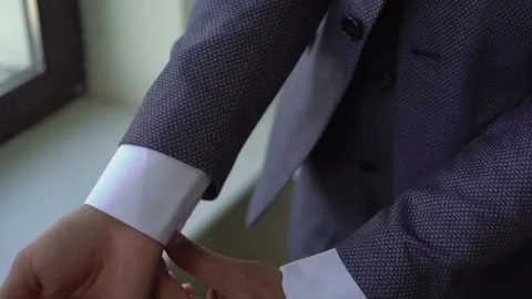Man is fastening a button on a gray jacket. Male wears a classic suit. Stock Footage 168886668
