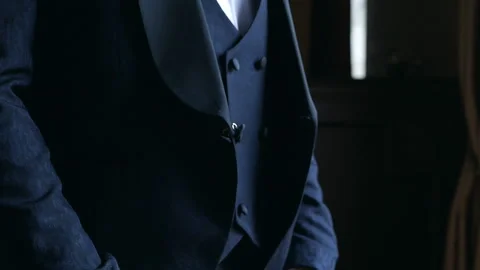 Man fastens a button on a classic blue jacket. Elegant man in a blue tuxedo Video stock 118297354