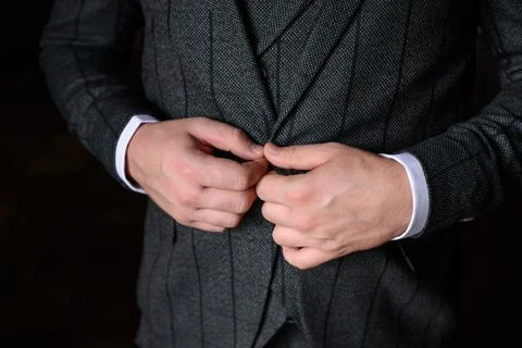 A man fastens a button on his jacket, close-up.Young modern businessman. Foto stock