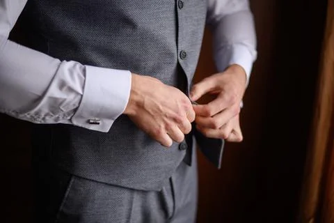 A man fastens a button on his jacket, close-up.Morning preparation of the groom. Foto stock