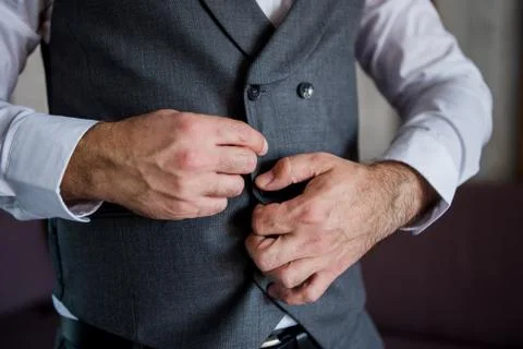 Man fastens a button on a jacket Stock Photos