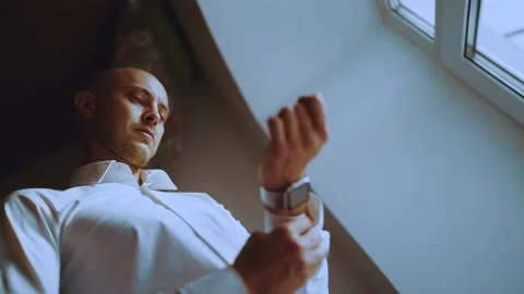 A man fastens a button on the sleeve of his shirt Stock Footage 200941533