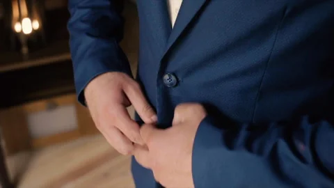 A man fastens the buttons on a blue jacket Stock Footage 149003142