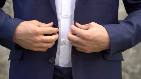 The man fastens buttons on his jacket close up. 스톡 동영상 76447508