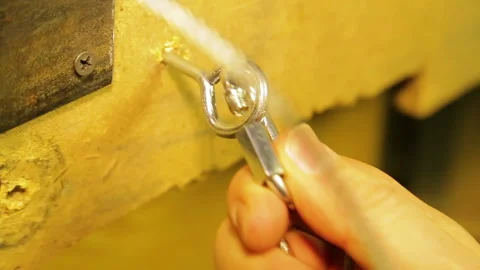 The man fastens to the mounting ring in the wall a safety cable for theatrical Stock Footage 104720487