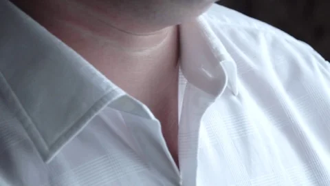 A man fastens the top button on a white shirt shirt Stock Footage 123002231
