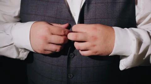 A man fastens a vest on himself while getting ready for work. Close-up shooting Stock Footage 330140401
