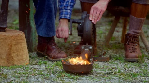 Man feed a fire with a tool Stockbeeldmateriaal 294208048