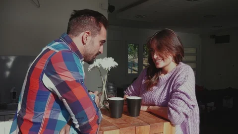 Man feeding smiling girlfriend with a cookie in the kitchen 스톡 동영상 99399031