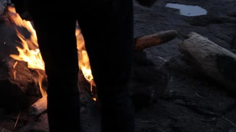 Man feeds fire on beach Stock-Footage 51935976