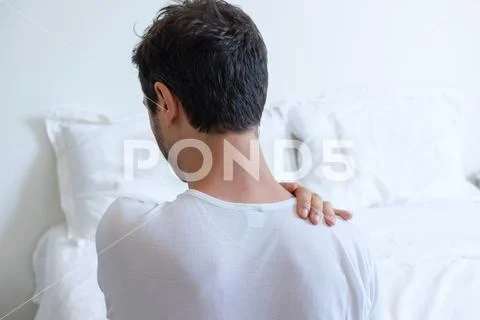 Man feeling back ache in the bed after sleeping Stock Photos