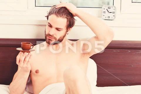 Man feeling back ache in the bed after sleeping. Picture showing young man Stock Photos