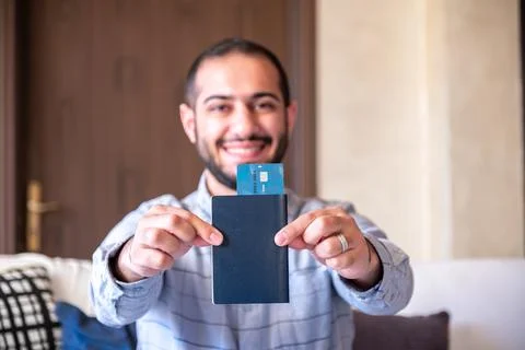 Man feeling excited while holding his bank card and passport for his new jo.. Stock Photos
