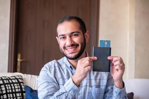 Man feeling excited while holding his bank card and passport for his new jo.. Stock Photos
